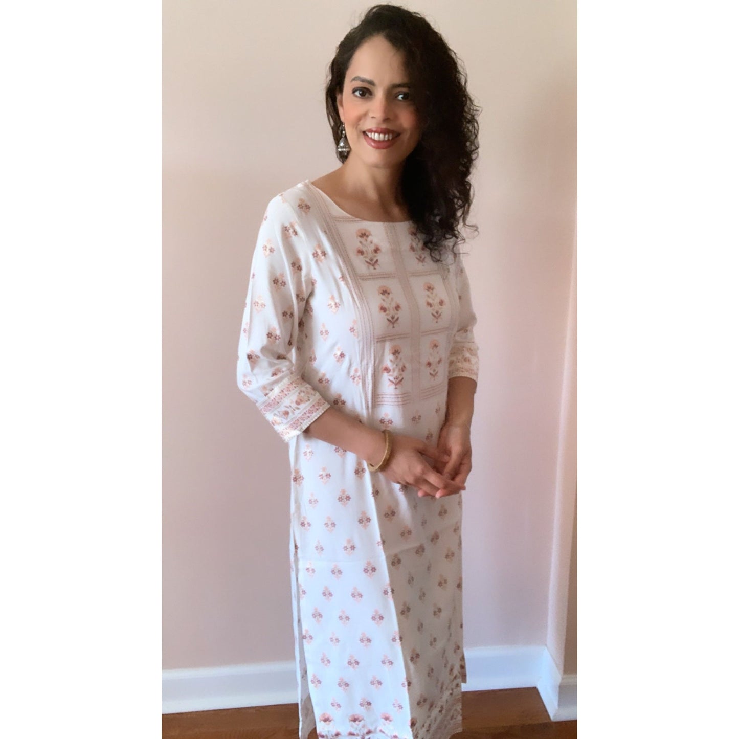 Graceful rayon Kurta in an off white shade with peach and gold prints all over. Wear with leggings or jeans 