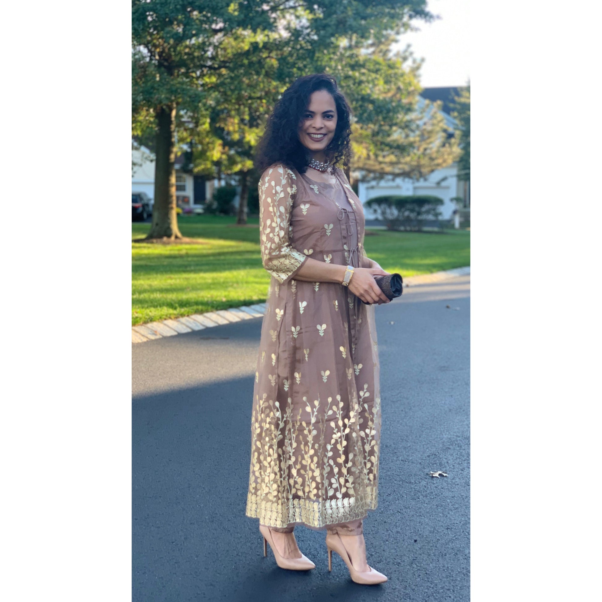 Brown Kurta with matching pants and a stunning full length net shrug. The shrug has pretty gold prints and dori strings in the front. 